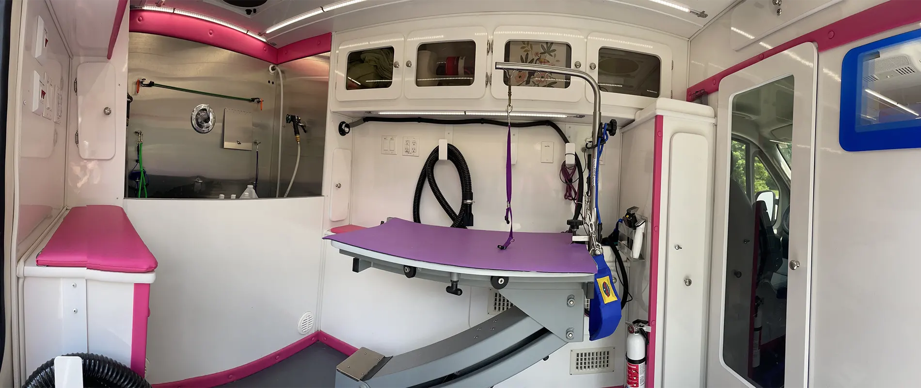 Wide Angle view of the interior of the Green Dog Mobile Spa Van showing the elevated Bathing sink, Clipping and Drying work station as well as general countertop